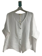 A white one size pure linen button fronted collarless shirt with three quarter sleeves.
