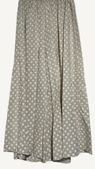 Beige wide leg trousers with white polka dots on a light gray background