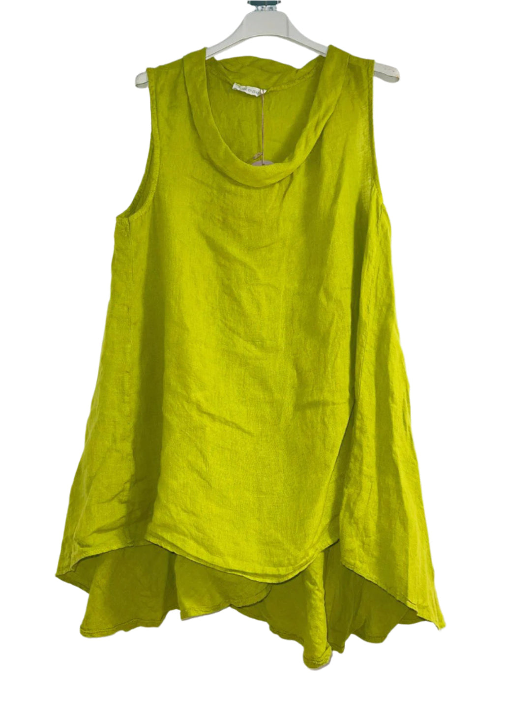 A woman wearing a lime green sleeveless cowl neck top with an asymmetrical hem, paired with white trousers.