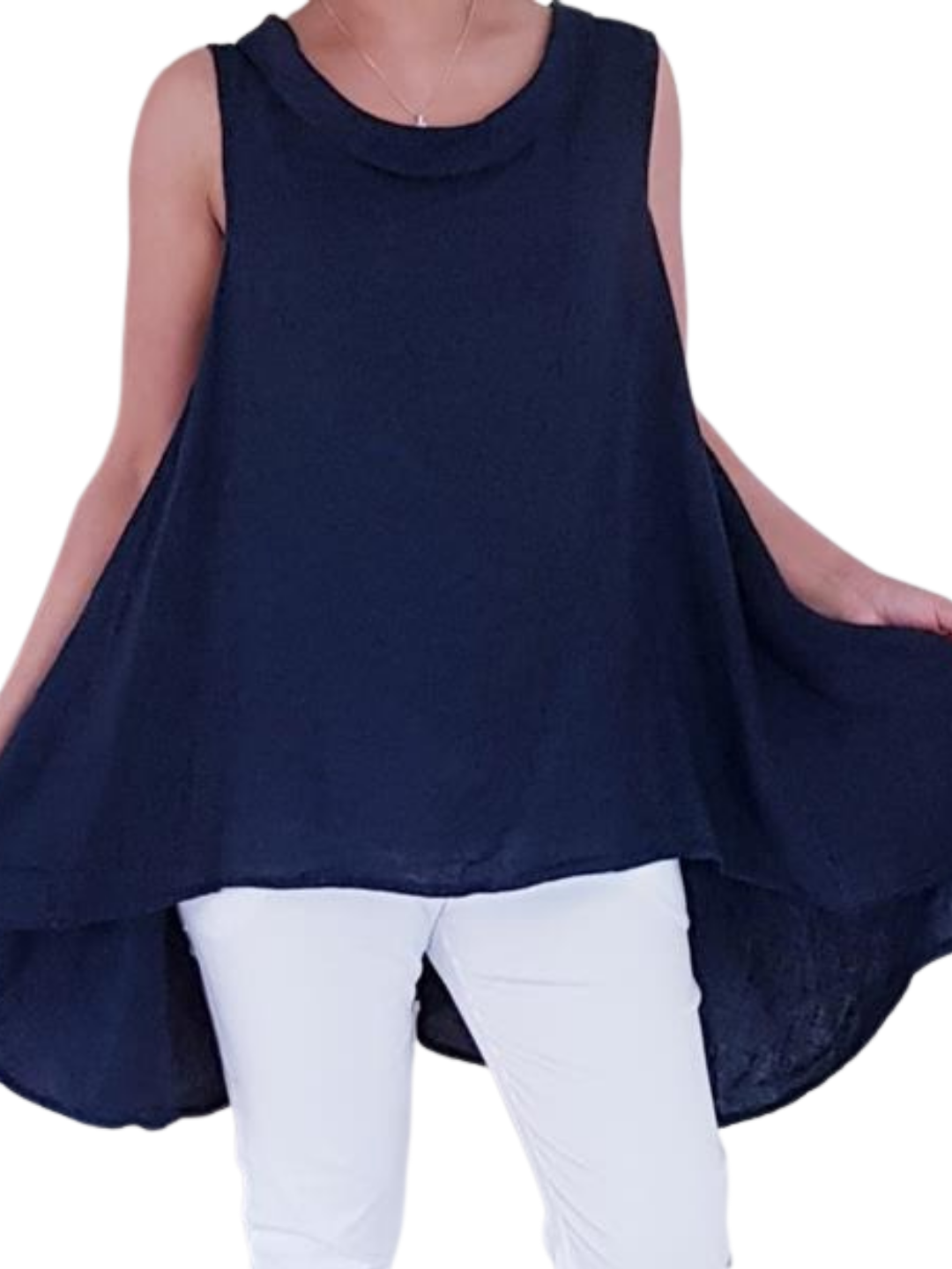 A woman wearing a navy blue sleeveless cowl neck top with an asymmetrical hem, paired with white trousers.